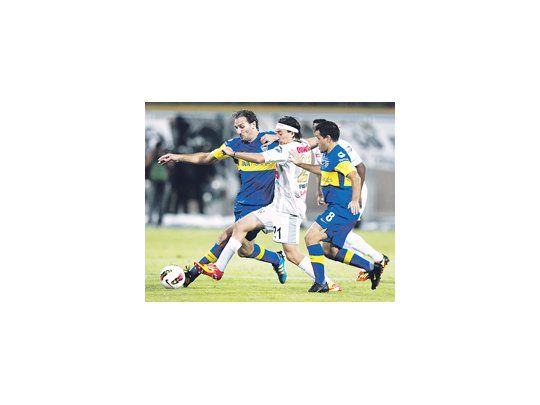 Rolando Schiavi anticipa al argentino Darío Figueroa, mientras Diego Rivero lo asiste. Boca no jugó bien y empató sin goles ante un discreto Zamora.