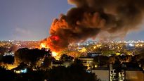 Bomberos trabajan en el depósito incendiado tras la explosión ocurrida durante la madrugada en San Fernando.