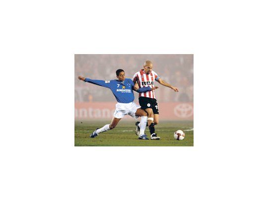 Juan Sebastián Verón lucha con Marquinhos. Estudiantes intentó, pero no pudo. Abajo, la gran fiesta previa de Estudiantes con bengalas multicolores y un espectáculo con rayos láser.