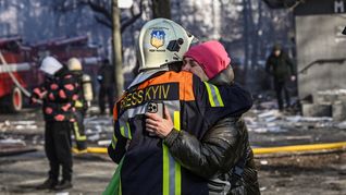 Un rescatista consuela a una mujer tras un ataque ruso en Kiev.