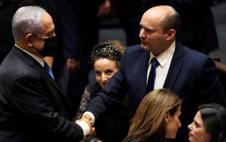 Benjamín Netanyahu estrecha la mano de su sucesor, Naftali Bennett.