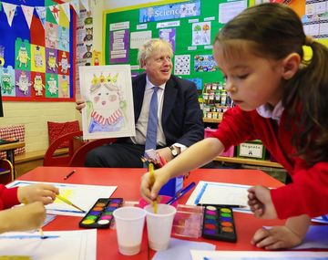 El primer ministro de Reino Unido, Boris Johnson, sostiene un dibujo de la reina Isabel II.