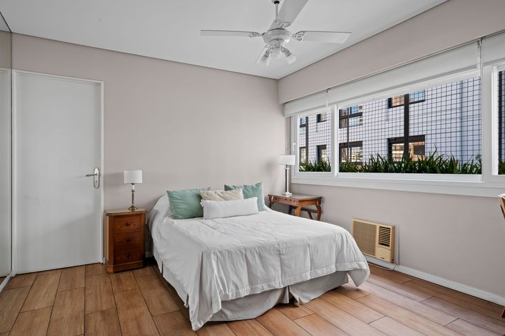 Uno de los dormitorios en suite, con luz natural y vistas abiertas, combina pisos de madera y diseño sobrio Uno de los dormitorios en suite, con luz natural y vistas abiertas, combina pisos de madera y diseño sobrio