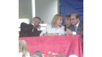 ámbito.com | Néstor Kirchner hace malabares para hablar por su teléfono celular mientras, a su lado, dialogan sonrientes la vice Graciela Giannettasio y el senador Antonio Arcuri.