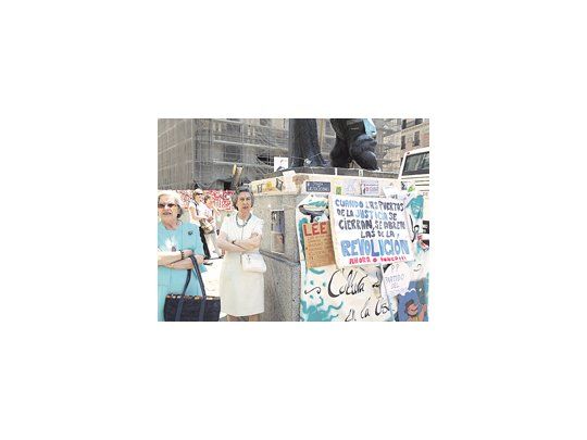 Damas madrileñas se acercan a ver a los jóvenes de la protesta, a los que critican. La asamblea entra en parálisis mientras «arbolitos» ofrecen oro y turistas sacan fotos.