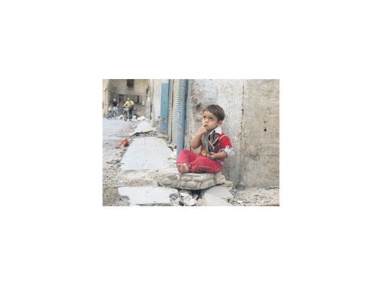 Un niño sentado en el portal de su casa en la ciudad de Homs, una de las más castigadas por el conflicto.