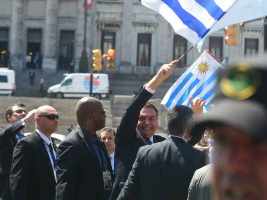 Jair Bolsonaro, agita una bandera de Uruguay en la asunci&oacute;n de Lacalle Pou.