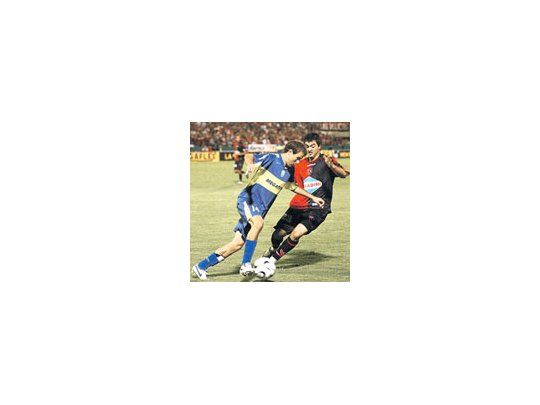 Rodrigo Palacio lucha con Gastón Aguirre. El delantero de Boca está recuperando su nivel y ayer marcó el gol del empate ante Newells en Rosario.