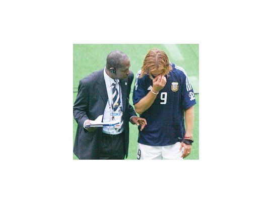 Gabriel Batistuta es consolado por un asistente de la FIFA cuando se retira del campo de juego. El delantero de Roma anunció que ´ésta fue su despedida del seleccionado argentino.