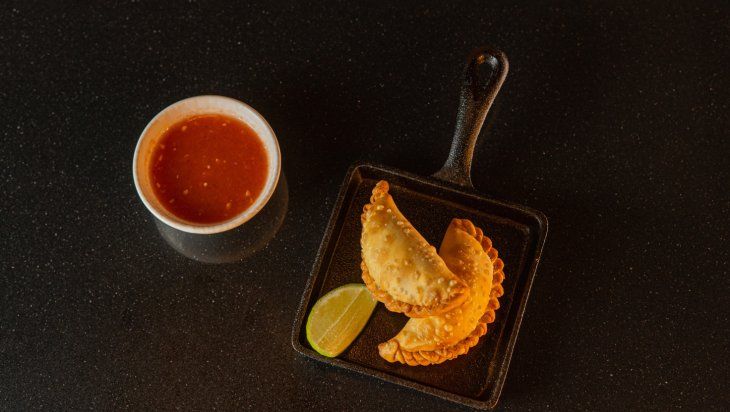 Sus empanadas se preparan con leche de coco, jengibre y jalapeño, acompañadas de la salsa llajua. Sus empanadas se preparan con leche de coco, jengibre y jalapeño, acompañadas de la salsa llajua.