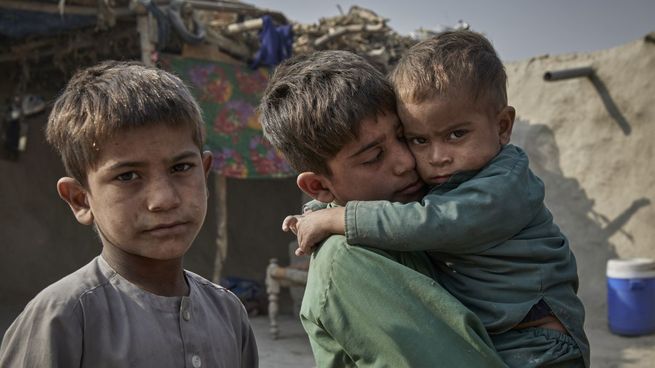 Niños desplazados internamente en un refugio temporal en Jalalabad, Afganistán. Uno de ellos lleva a su hermano enfermo en brazos.&nbsp;