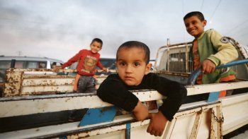 HUIDA. Un grupo de niños escapa de la ciudad Ras al Ain, Siria, blanco de ataques de las fuerzas turcas.