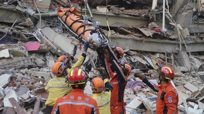 Miembros de un equipo chino de búsqueda y rescate traslada a una sobreviviente embarazada desde un edificio derruido tras un sismo en Mandalay, Myanmar, hoy.