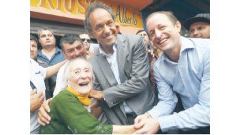 Daniel Scioli y Martín Insaurralde se disputan el afecto de una vecina de Lomas de Zamora. Hoy el candidato seguirá caminando el conurbano: toca Florecio Varela.