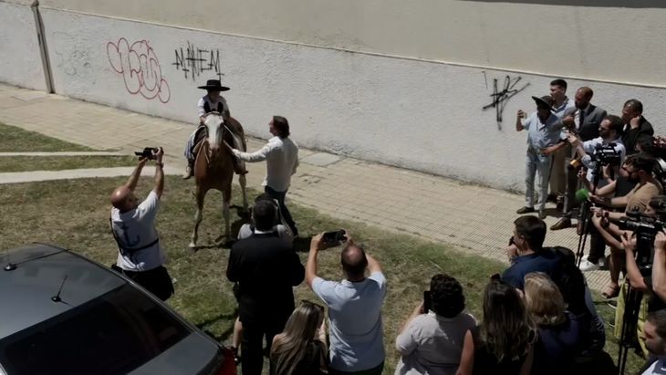 President Luis Lacalle Pou received a gift from a child on horseback. President Luis Lacalle Pou received a gift from a child on horseback.