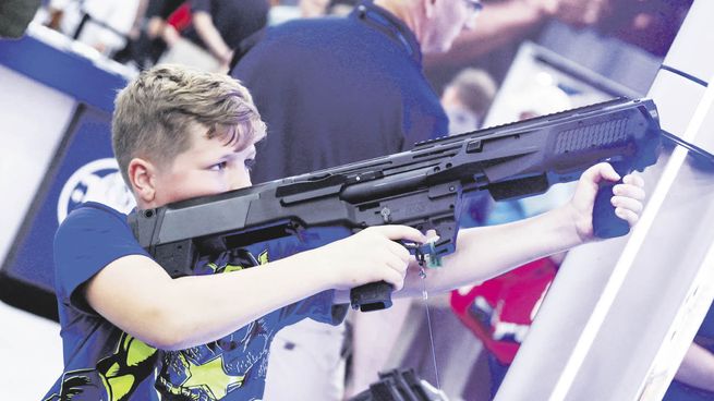 PASIÓN NACIONAL. Un niño dispara durante la última convención de la Asociación Nacional del Rifle (NRA), realizada en mayo en Houston, Texas.