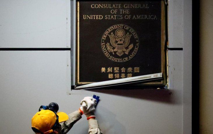 Un funcionario chino retira la placa de identificaci&oacute;n del consulado de Estados Unidos en Chengdu.