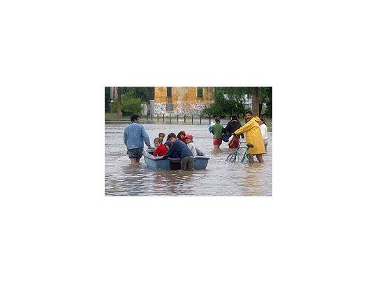 Un grupo de niños es evacuado en un bote en Quilmes debido a la sudestada que afecta a la rivera de esa localidad.