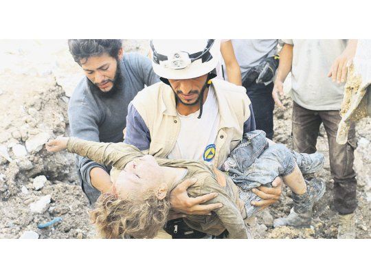 Más muerte. Un rescatista traslada el cuerpo de un niño fallecido por los bombardeos del régimen de Bashar al Asad en las zonas de Alepo controladas por grupos rebeldes e islamistas.