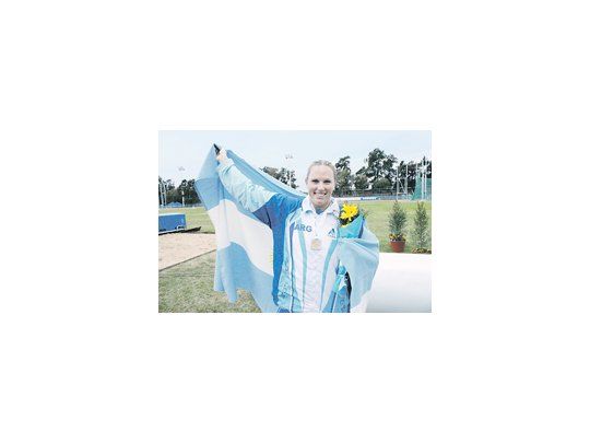 Jennifer Dahlgren envuelta en la bandera argentina tras conseguir el Oro en lanzamiento de martillo.