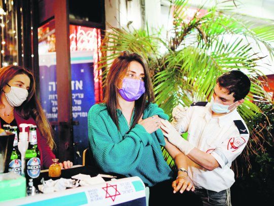 MOTIVACIÓN. Una mujer es vacunada en Tel Aviv. La municipalidad de la ciudad ofreció a sus ciudadanos una bebida a cambio de acceder a inocularse.&nbsp;