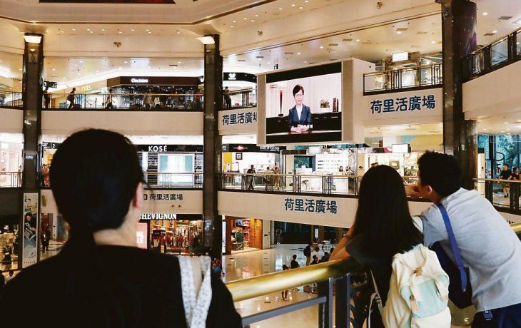 ANUNCIO. Hongkoneses observan la conferencia de la jefa del Ejecutivo, Carrie Lam. Se espera que al retirar la medida, terminen las protestas.
