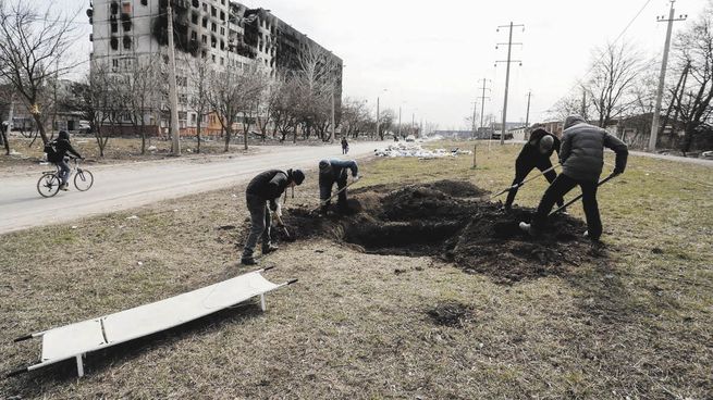 DESESPERANZA. Un grupo de hombres cavan fosas para civiles en Mariúpol, que es blanco de bombardeos permanentes por parte de Rusia desde que comenzó el conflicto hace más de tres semanas.