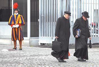 Los cardenales estadounidenses Daniel Di Nardo  y Raymond Leo Burke salen de la reunión matinal de purpurados.