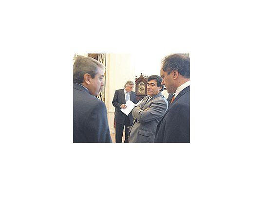 Néstor Kirchner, ayer, revisa papeles en Casa de Gobiernomientras Carlos Zannini sonríe ante la seriedad de AníbalFernández.