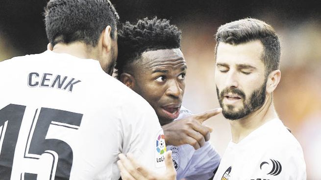 Sacado. El mediocampista brasileño del Real Madrid es contenido por jugadores del Valencia luego de sufrir insultos racistas y de ser expulsado el último domingo del encuentro que su equipo terminó perdiendo.