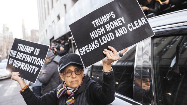 REACCIÓN. Decenas de personas se acercaron a las inmediaciones del tribunal de Nueva York. Una persona sostiene un cartel que reza “El dinero de Trump habla muy fuerte y claro”.