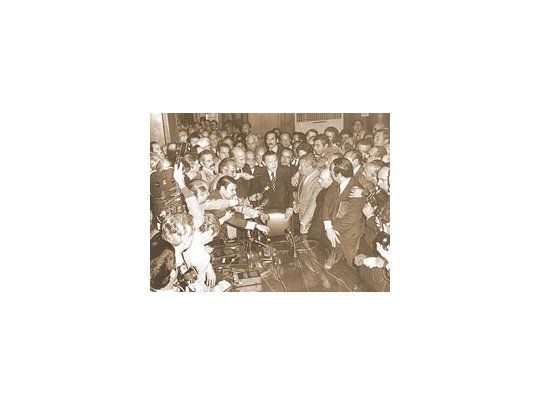 Los ministros salían del despacho presidencial del Gral. Perón (tercera presidencia) en 1973 y se prestaban a las preguntas de los periodistas de la Casa de Gobierno. En la foto, el ministro de Economía en ese año, José Gelbard (centro tras la silla); a su derecha, el titular del Banco Central y futuro ministro, Alfredo Gómez Morales, y los clásicos acreditados Piñero, Di Sandro, José Corzo Gómez (una mano sobre el ministro). Derecha atrás, mirando abajo, Sergio Villarruel (padre).