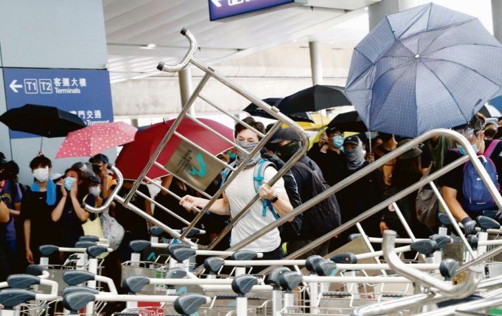 In crescendo. Los manifestantes prodemocracia armaron barricadas en el aeropuerto de Hong Kong con los carritos para transportar valijas y destruyeron varias cámaras de seguridad.