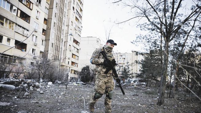 cercanía. Un soldado ucraniano camina cerca de un edificio ubicado en los suburbios de Kiev que fue alcanzado por un misil ruso. Las tropas del Kremlin seguían avanzando hacia el corazón de la capital.