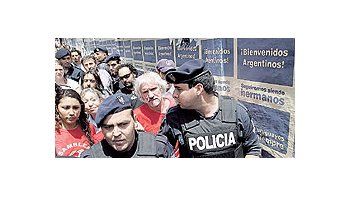 ámbito.com | Policías uruguayos custodian a los asambleístas argentinos que viajaron a Montevideo para protestar contra Botnia. Atrás, afiches de la campaña oficial para atraer turistas.