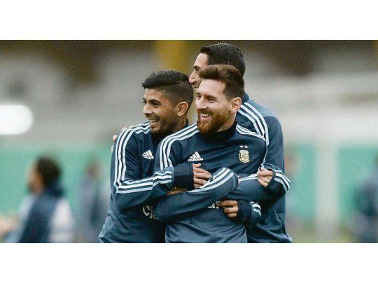 Se divierten. Ever Banega y Ángel Di María sostienen a Lionel Messi para que no se mueva, explicando como tienen que marcarlo los rivales.