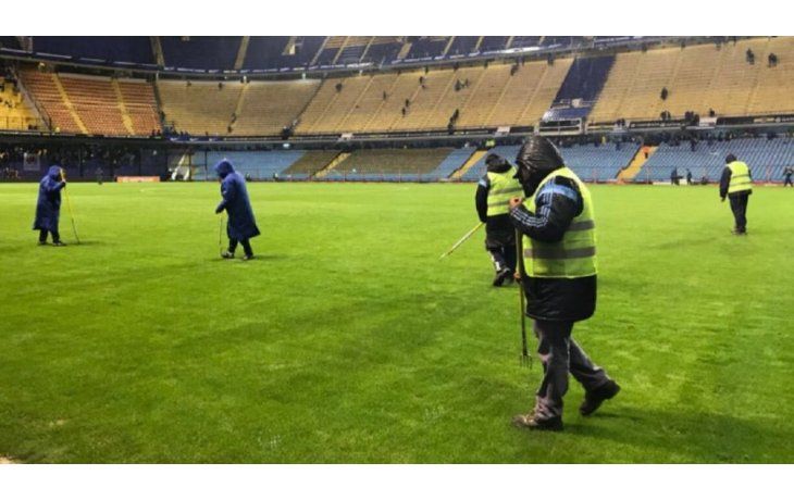 Empleados de Boca Juniors reacondicionan el césped donde jugarán Argentina y Perú por las Eliminatorias sudamericanas.
