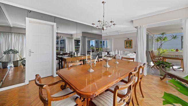 El comedor formal con pisos de parquet y salida a la terraza cubierta conecta con el área social del primer nivel.