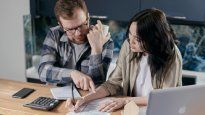 Una pareja analiza números y proyecciones ante la propuesta oficial de eximir Ganancias en la venta y el alquiler de viviendas, con impacto desde 2026 en el mercado inmobiliario