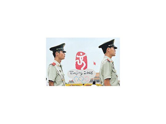 Soldados chinos montan guardia en la Plaza de Tiananmen de Pekín frente al emblema de los Juegos Olímpicos que comenzarán en una semana.Las restricciones a la prensa ponen en evidencia ante el mundo el carácter represivo del régimen.
