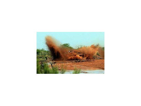 La aventura en todos los colores. Un auto cruza a toda velocidad el charco y llena de colores la escenografía. Una de las tantas bellezas que nos regaló este Dakar 2011.