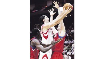 Luis Scola entre Jrue Holiday y Spencer Hawes. A pesar de la gran actuación del argentino, los Rockets cayeron ante Philadelphia.