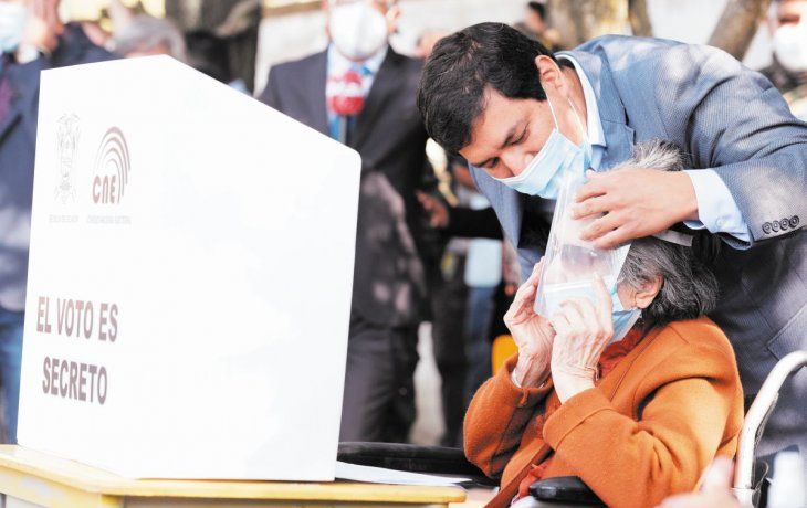 VOTOS Y MÁSCARAS. El izquierdista Andrés Arauz acompañó ayer a su abuela de 106 años a votar en un colegio de Quito.
