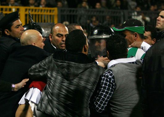 La policía intenta detener a los hinchas que entraron a la cancha.