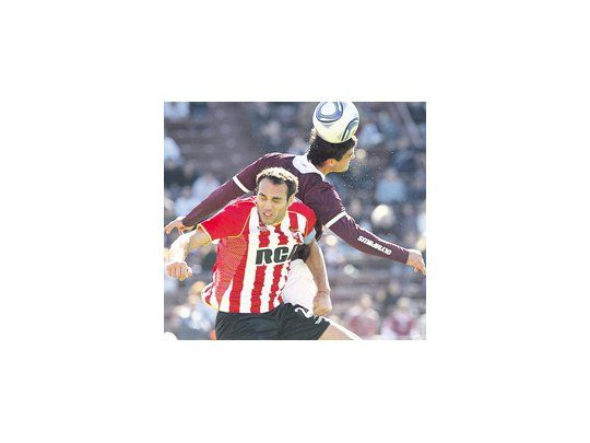 Silvio Romero salta con Leandro Desábato. Una escena de lucha, en un partido que tuvo poco fútbol.
