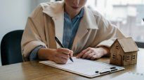 Una compradora firma la escritura de una vivienda en Buenos Aires, en un mercado que muestra señales de estabilización de precios