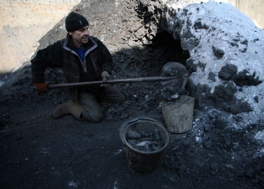 Un vagabundo llena un pozo con carbón para refugiarse en Donetsk, Ucrania.
