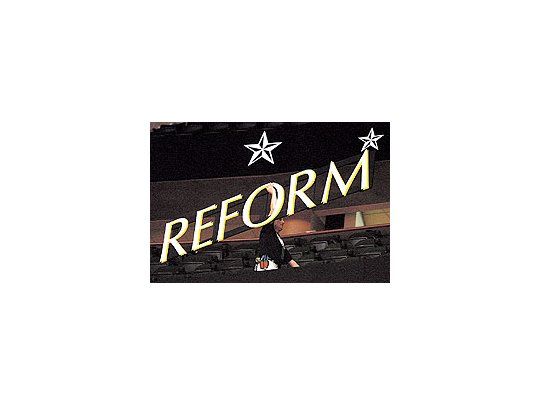 Un trabajador carga un cartel con la palabra «reforma» en la sede de la convención republicanade Saint Paul. John McCain fue uno de los defensores de una iniciativa de reformamigratoria destinada a regularizar a millones de hispanos. Sin embargo, ahora cede antelos más duros de su partido y pone en peligro el apoyo de ese sector clave del electorado.