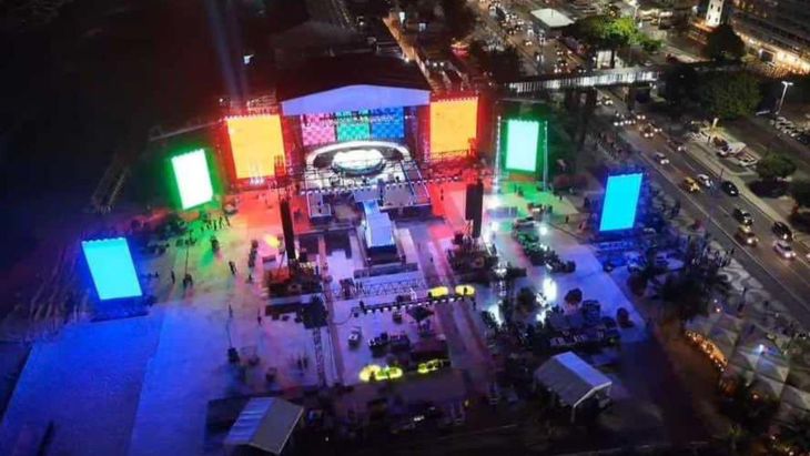 The stage is surrounded by platforms and giant screens. 