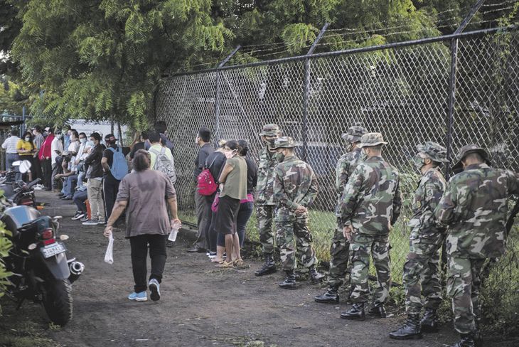 POSTAL. Civiles y militares ayer, al ingresar a un centro electoral de Managua. El sandinismo ajusta todas las clavijas de su sistema de poder.